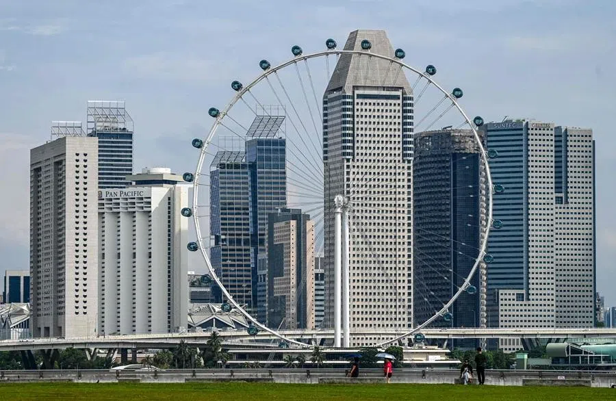 The Singapore flyer observation wheel sits against the high-rise buildings in Singapore on 21 April 2026. (Roslan Rahman/AFP)