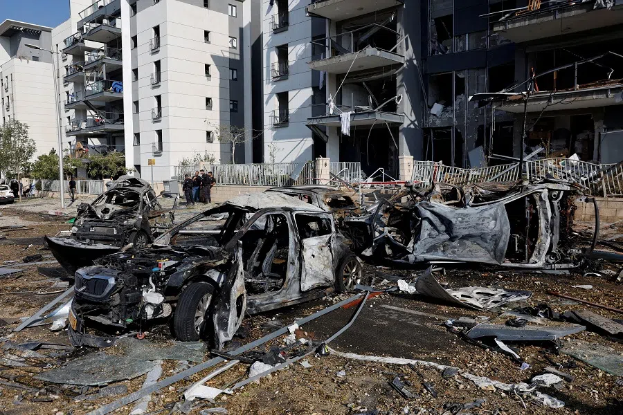 Emergency personnel work next to burnt cars and damaged residential buildings at an impact site following Iran’s missile strike on Israel, in Be’er Sheva, Israel, on 20 June 2025.