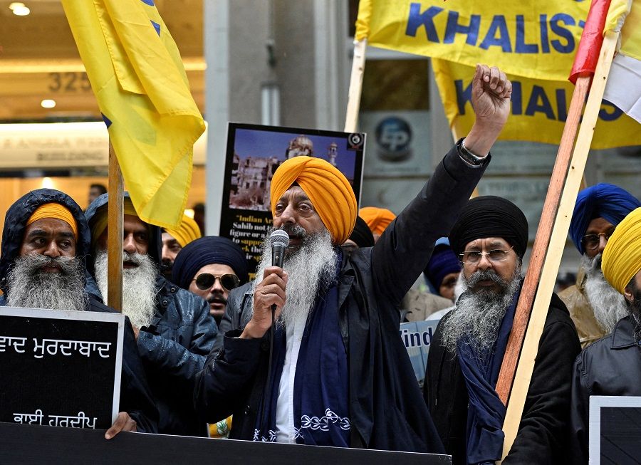 A demonstrator uses a microphone as others hold flags and signs as they protest outside India's consulate, a week after Canada's Prime Minister Justin Trudeau raised the prospect of New Delhi's involvement in the murder of Sikh separatist leader Hardeep Singh Nijjar, in Vancouver, British Columbia, Canada, 25 September 2023. (Jennifer Gauthier/Reuters)