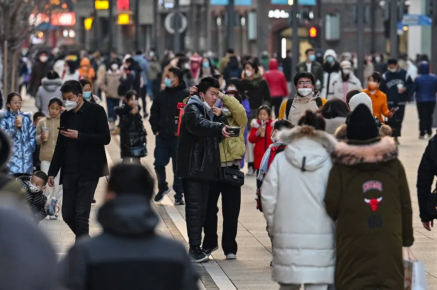 People walk on a pedestrian street in the Huangpu district in Shanghai, China, on 16 January 2023. (Hector Retamal/AFP)