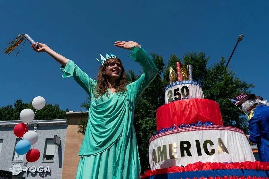 A woman dressed as the Statue of Liberty waves from a float with a 250th birthday cake during the Capitol Hill Community 4th of July Parade marking the 250th anniversary of US Independence, in Washington, DC, US, on 4 July 2026.