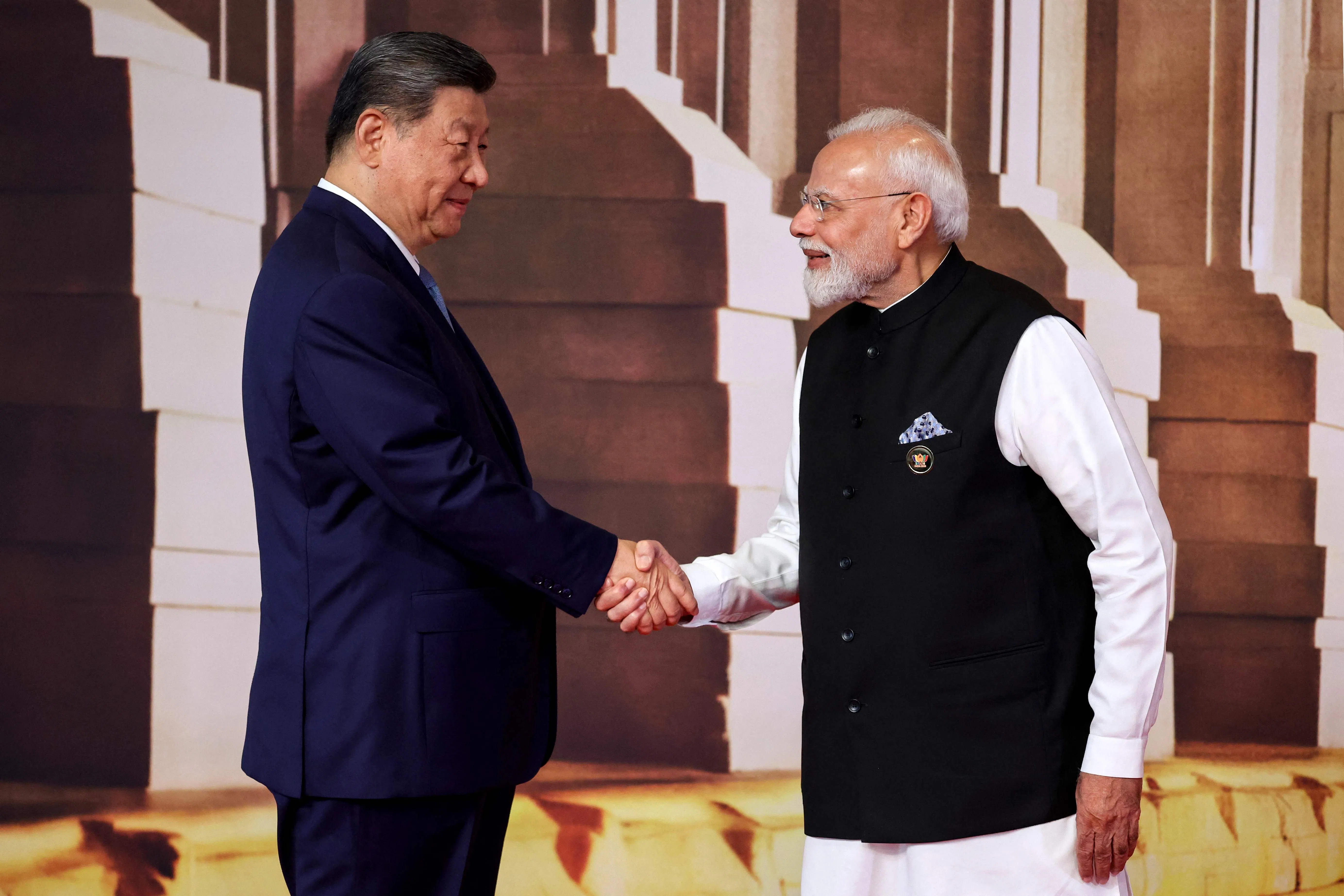 In this pool photograph distributed by the Russian state agency Sputnik, India's Prime Minister Narendra Modi (right) shakes hands with China's President Xi Jinping during a welcome ceremony before the start of the 18th BRICS Summit in New Delhi on 12 September 2026.
