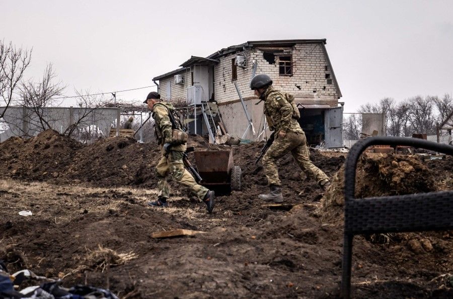 Ukrainian servicemen run at the front line east of Kharkiv, Ukraine, on 31 March 2022. (Fadel Senna/AFP)