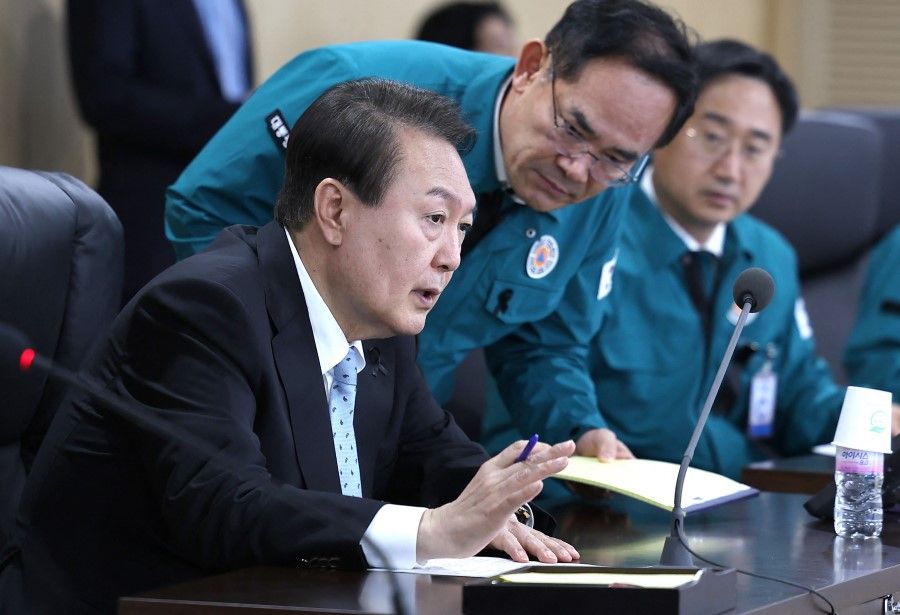 This handout photo taken and released on 2 November 2022 by the South Korean Presidential Office via Yonhap news agency shows South Korean President Yoon Suk-yeol (left) speaking at a meeting of the National Security Council over North Korea's missile launch, at the presidential office in Seoul. (Handout/South Korean Presidential Office/AFP)