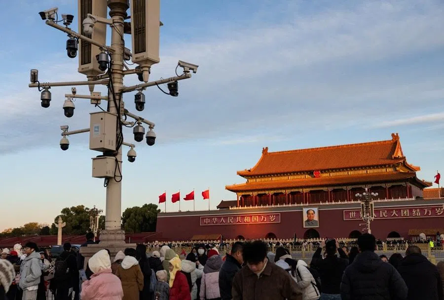People gather at Tiananmen Square as Tiananmen Gate, featuring a portrait of late Chinese Chairman Mao Zedong, is illuminated by the sunrise in Beijing, China, on 20 November 2025. (Maxim Shemetov/Reuters)