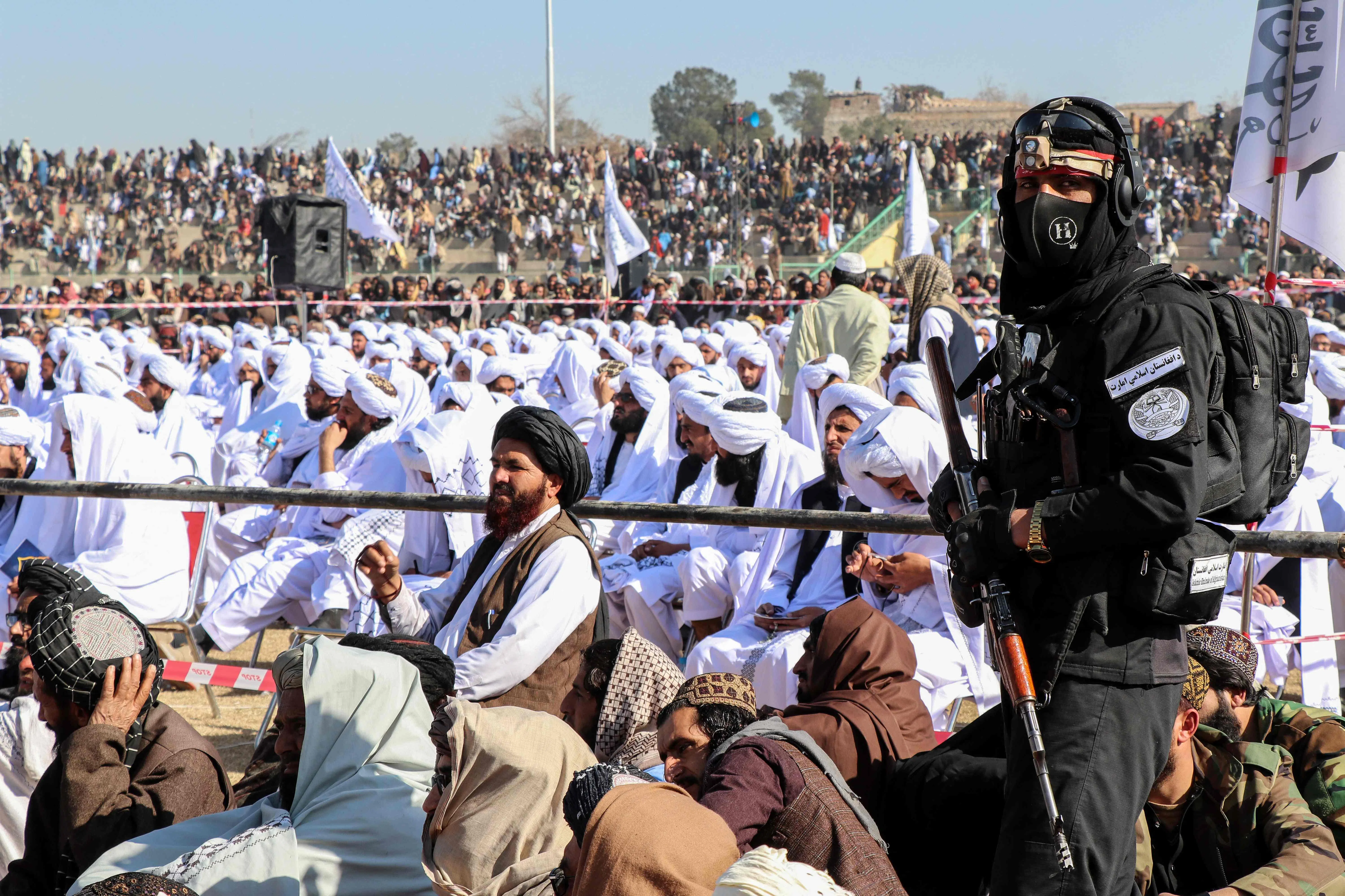 A Taliban security personnel stands guard as newly graduated students from Manba-ul-Jihad, a madrassa or Islamic school, attend their graduation ceremony in Khost on 24 January 2025. (AFP)