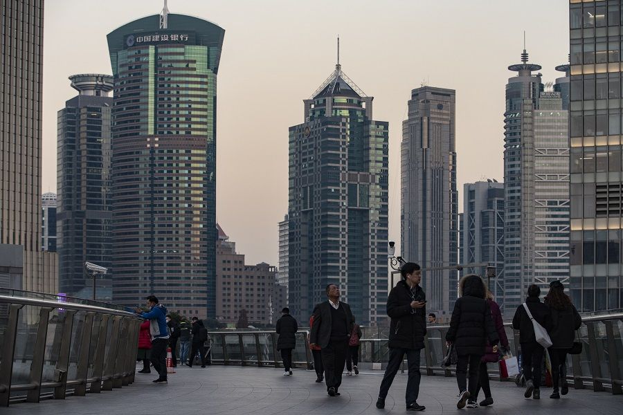 Pedestrians walk on an overpass in the Lujiazui financial district in Shanghai, China, on 21 December 2020. (Qilai Shen/Bloomberg)