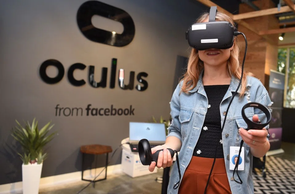 In this file photo taken on 23 October 2019, a Facebook employee tries out an Oculus device at the company's corporate headquarters campus in Menlo Park, California. (Josh Edelson/AFP)