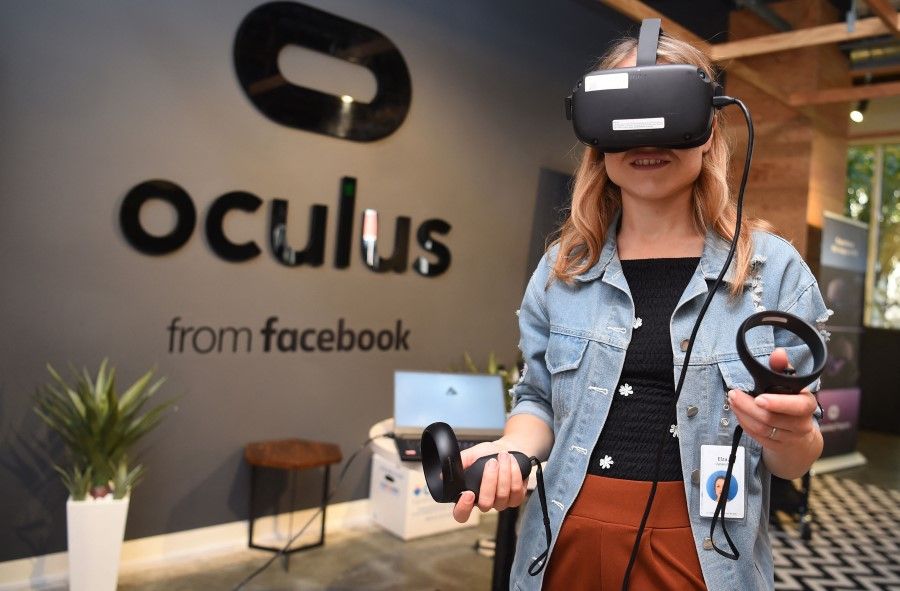 In this file photo taken on 23 October 2019, a Facebook employee tries out an Oculus device at the company's corporate headquarters campus in Menlo Park, California. (Josh Edelson/AFP)