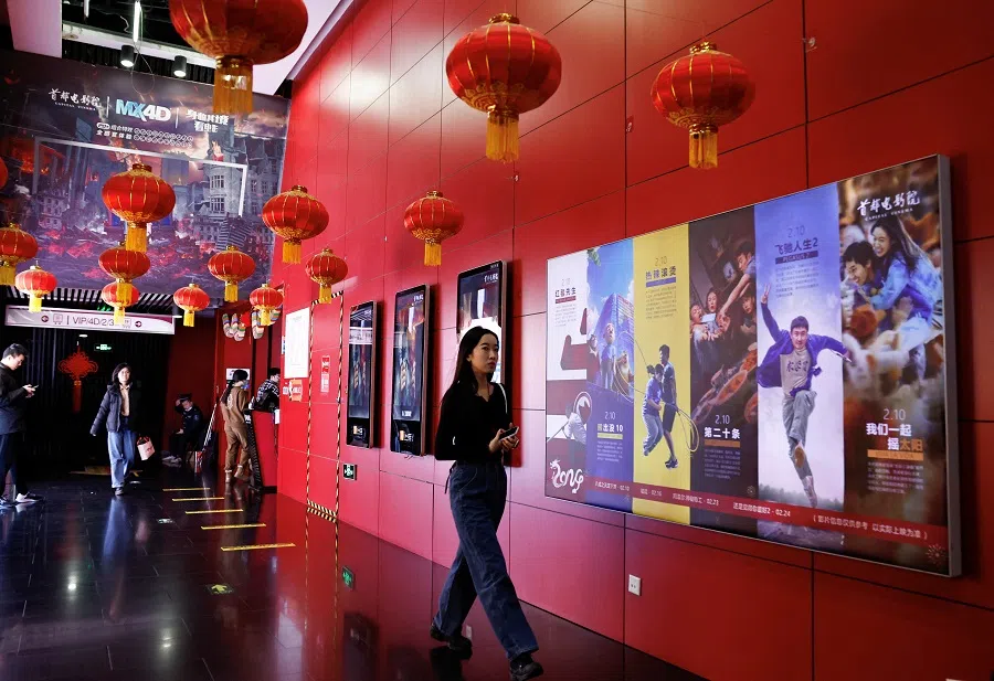 A person walks past movie posters at a cinema in Beijing, China, on 21 February 2024. (Tingshu Wang/Reuters)