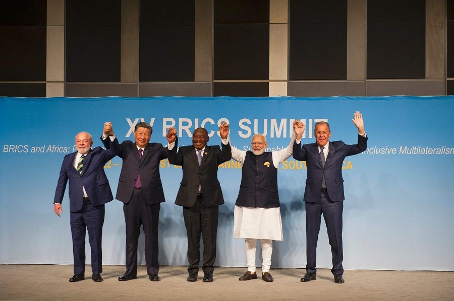 From left: Brazil's President Luiz Inacio Lula da Silva, China's President Xi Jinping, South African President Cyril Ramaphosa, Indian Prime Minister Narendra Modi and Russia's Foreign Minister Sergei Lavrov raise their arms as they pose for a group photograph, at the BRICS Summit in Johannesburg, South Africa on 23 August 2023. (Alet Pretorius/Pool/AFP)