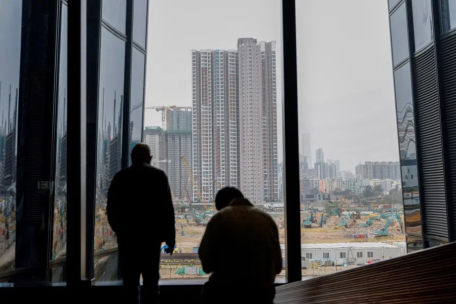 A man looks at the construction site of residential units, in Hong Kong, China, on 27 February 2024. (Tyrone Siu/Reuters)