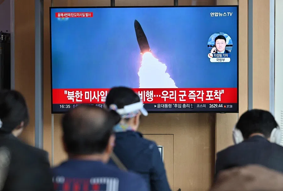 People watch a television screen showing a news broadcast with file footage of a North Korean missile test, at a railway station in Seoul, South Korea, on 22 April 2024. (Jung Yeon-je/AFP)