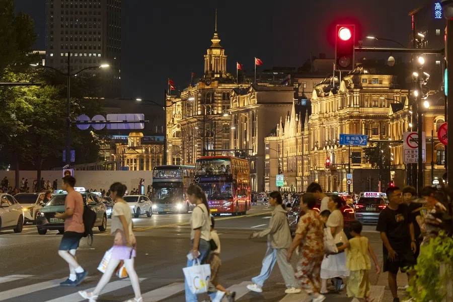 Pedestrians along the Bund at night in Shanghai, China, on 15 August 2024. (Qilai Shen/Bloomberg)