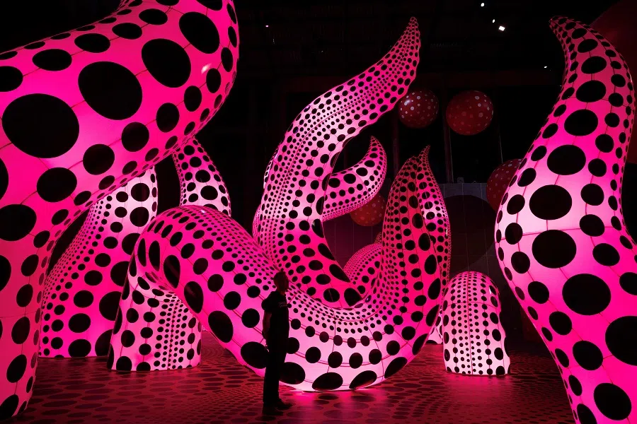 A man admires an artwork entitled "A Bouquet of Love I Saw in the Universe" which features in an exhibition by Japanese artist Yayoi Kusama entitled 'You, Me and the Balloons' in the Aviva Studios gallery in Manchester, England on 29 June 2023. (Oli Scarff/AFP)