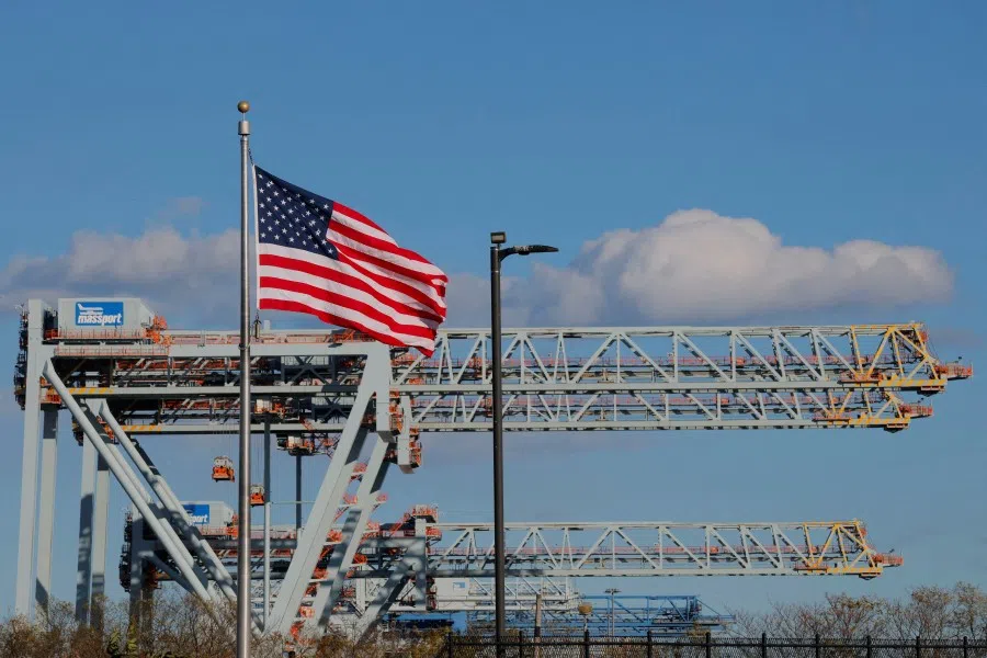 A US flag flies in front of cranes at the Conley Container Terminal, as the US Supreme Court is set to consider the legality of US President Donald Trump’s global tariffs, in Boston, Massachusetts, US, 4 November 2025. (Brian Snyder/Reuters)