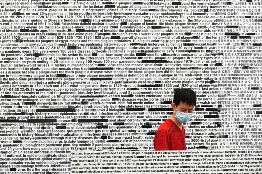 A man wearing a face mask amid concerns of the Covid-19 coronavirus looks at "Make Bad Cookies" by Payne Zhu as he visits the exhibition 'Meditations in an Emergency' at UCCA Center for Contemporary Art in Beijing, 13 June 2020. (Wang Zhao/AFP)
