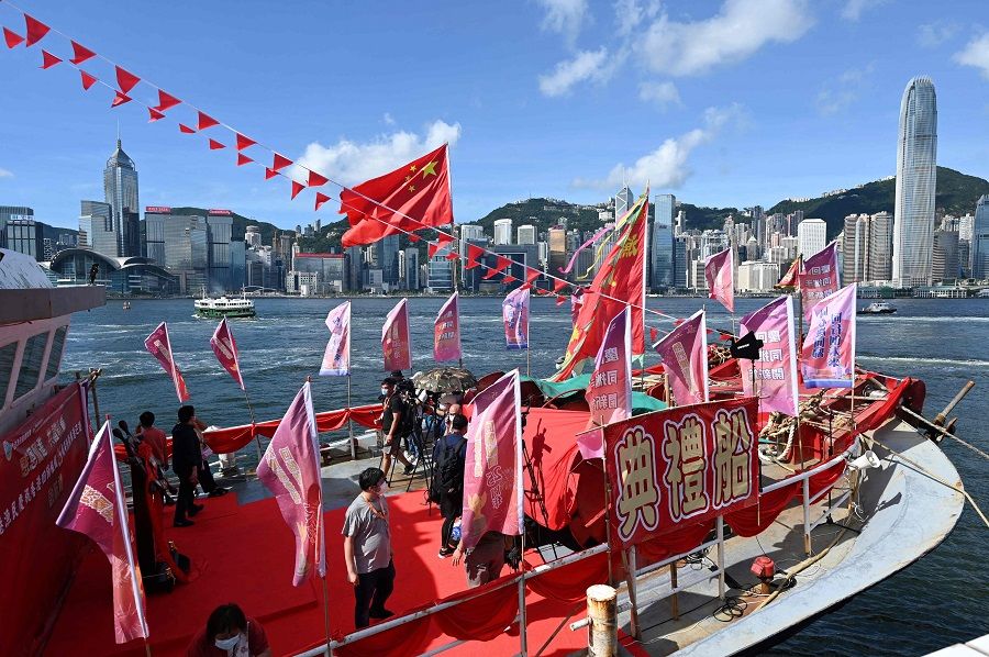 A fishing boat with banners and flags to mark the 25th anniversary of the Handover of Hong Kong from Britain to China is moored in Hong Kong's Victoria Harbour on 28 June 2022. (Peter Parks/AFP)