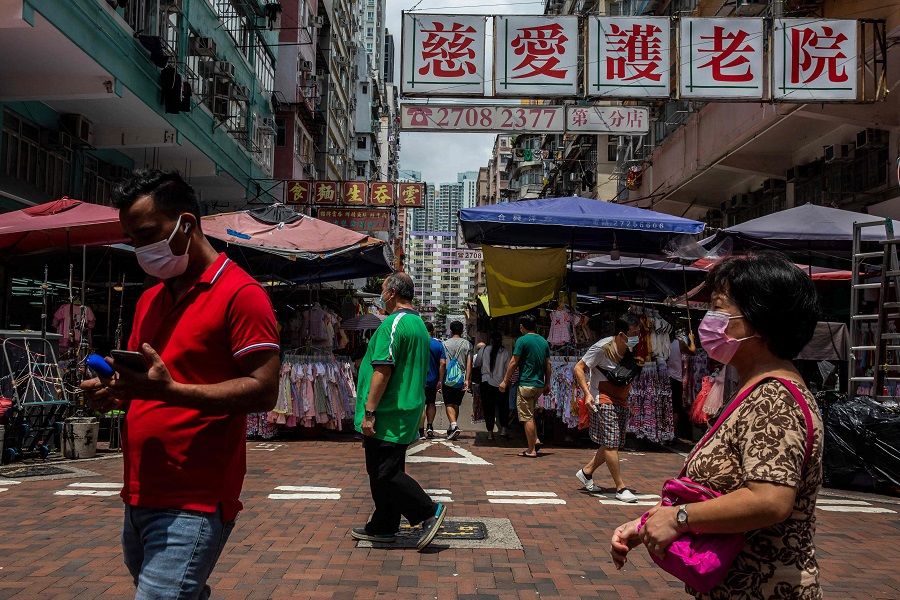 People walk through the markets in the Kowloon district of Hong Kong on 9 August 2021. (Isaac Lawrence/AFP)
