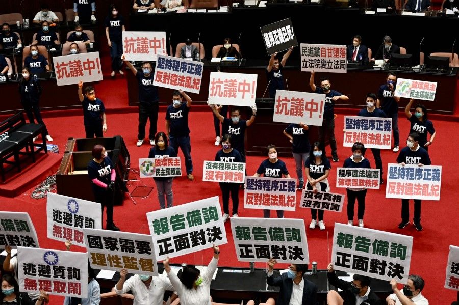 Taiwan's main opposition Kuomintang (KMT) legislators display placards that read "keep the Procedural Justice" as they protest calling for the government to apologise for coronavirus deaths, at the Parliament in Taipei on 1 October 2021. (Sam Yeh/AFP)