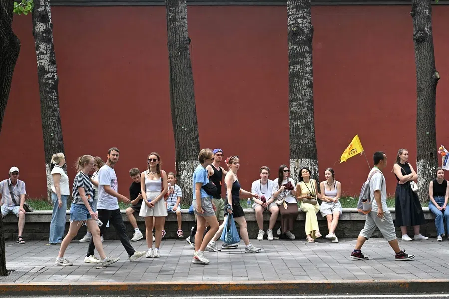 Foreign tourists walk past Jingshan park in Beijing on 13 August 2026.