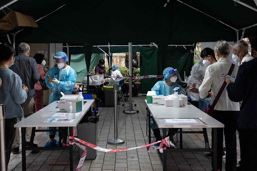 Health workers inspect health codes of residents during Covid-19 tests of the entire population in Macau, China, on 1 November 2022. (Eduardo Leal/AFP)