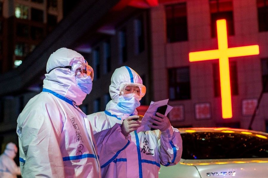 This photo taken on 25 April 2020 shows medical workers wearing protective gear looking for close contacts with patients that tested positive for the coronavirus in Suifenhe, Heilongjiang. (STR/AFP)
