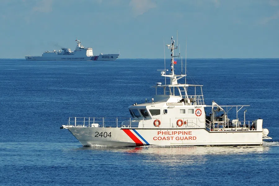 This file photo taken on 14 May 2019 shows a Philippine coast guard ship (right) sailing past a Chinese coast guard ship during a joint search and rescue exercise between the Philippines and US coast guards near Scarborough Shoal in the South China Sea. (Ted Aljibe/AFP)