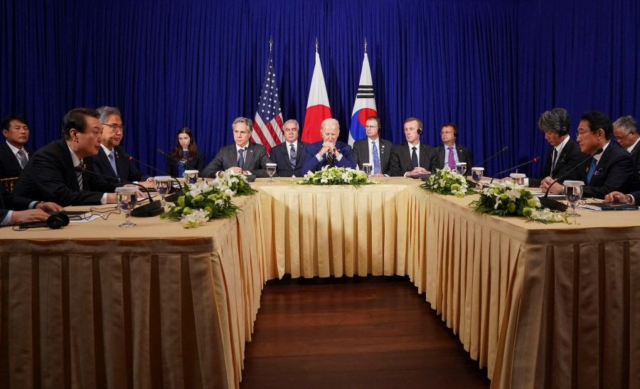 US President Joe Biden attends a trilateral meeting with South Korean President Yoon Suk-yeol and Japanese Prime Minister Fumio Kishida (right), in Phnom Penh, Cambodia, 13 November 2022. (Kevin Lamarque/Reuters)