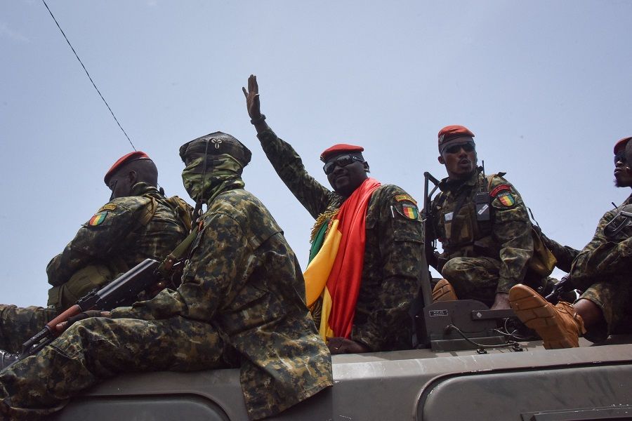 Lieutenant Colonel Mamady Doumbouya (centre), head of the army's special forces and coup leader, waves to the crowd as he arrives at the Palace of the People in Conakry, Guinea on 6 September 2021. (Cellou Binani/AFP)
