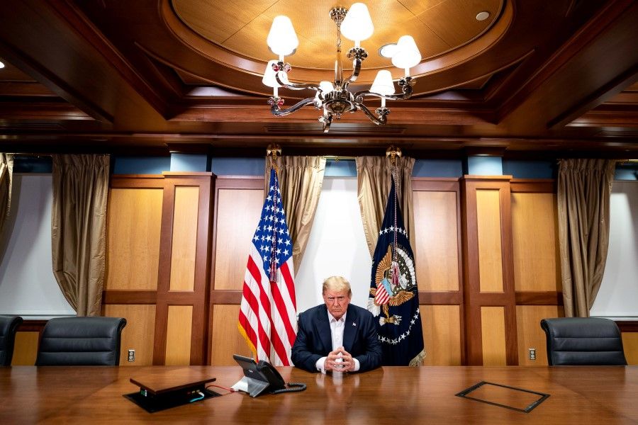 US President Donald Trump participates in a phone call with Vice President Mike Pence, Secretary of State Mike Pompeo, and Chairman of the Joint Chiefs of Staff Gen. Mark Milley, 4 October 2020, in his conference room at Walter Reed National Military Medical Center in Bethesda, Maryland. (Tia Dufour/The White House/Handout via REUTERS)