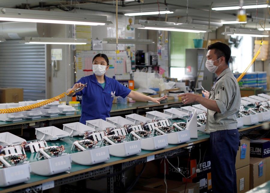 Factory employees at an assembly line of ventilators in Saitama, Japan, 8 May 2020. (Issei Kato/REUTERS)
