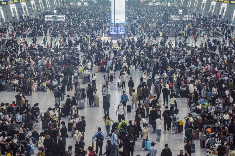 Passengers arrive at Hangzhou East train station in Hangzhou, in China's eastern Zhejiang province on 28 April 2023. (AFP)