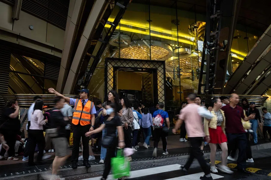 A security guard directs the crowd outside Grand Lisboa integrated resort in Macau on 1 May 2024. (Eduardo Leal/AFP)
