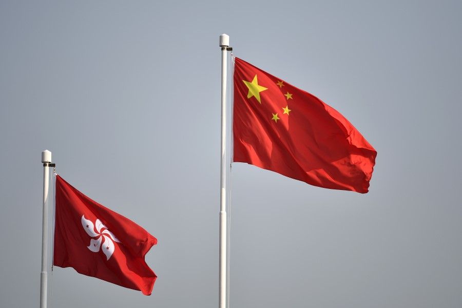 The Chinese national flag (right) flies alongside the Hong Kong flag. (Anthony Wallace/AFP)