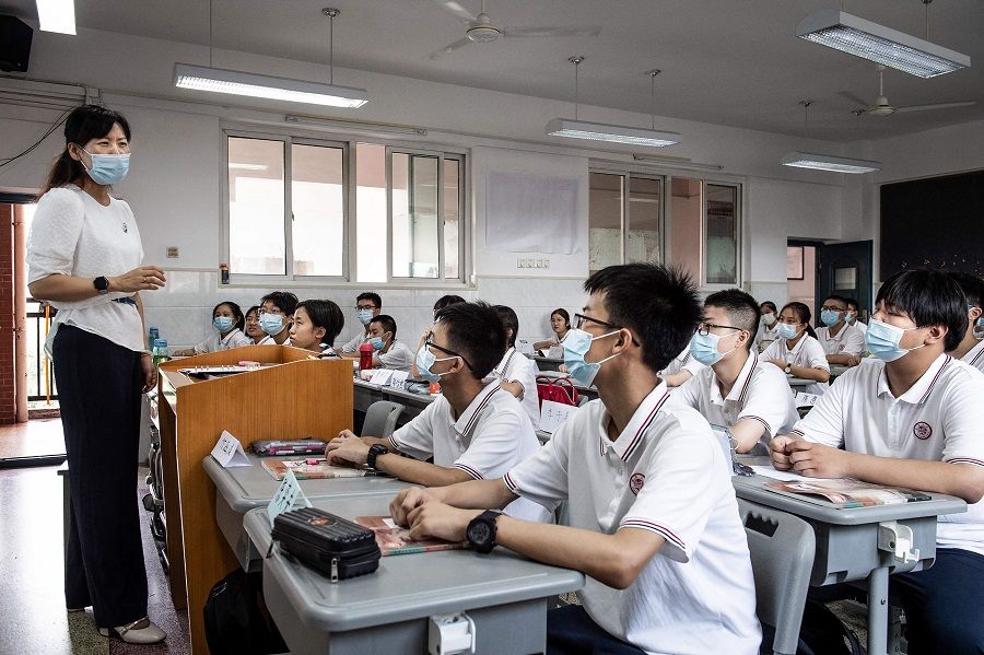 Students listen to a teacher on the first day of the new semester in Wuhan, Hubei province, China, on 1 September 2021. (STR/AFP)