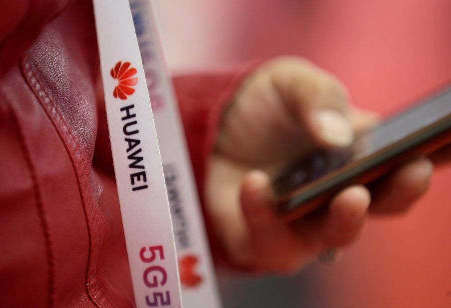An attendee wears a lanyard with the logo of Huawei and a sign for 5G at the World 5G Exhibition in Beijing, China, 22 November 2019. (Jason Lee/File Photo/Reuters)