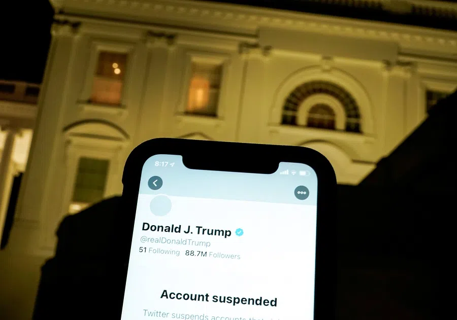 A photo illustration shows the suspended Twitter account of former US President Donald Trump on a smartphone and the White House in Washington, US, on 8 January 2021. (Joshua Roberts/Illustration/File Photo/Reuters)