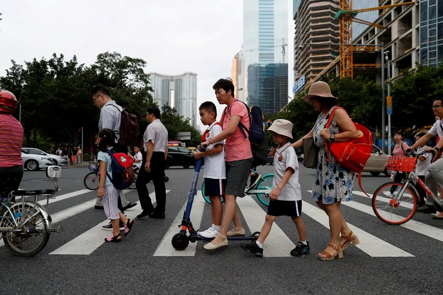 Children and their parents are seen on their way to school in Guanghzou, China, on 4 September 2019. (Jorge Silva/Reuters)