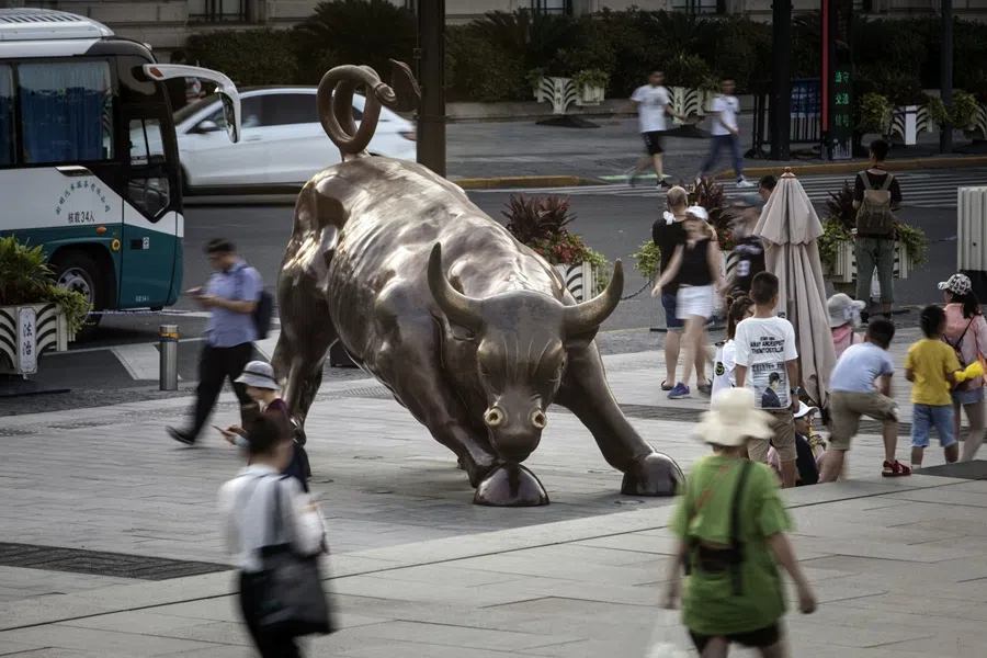 Pedestrians walk past the Bund Bull statue in Shanghai, China, on 29 July 2019. (Qilai Shen/Bloomberg)