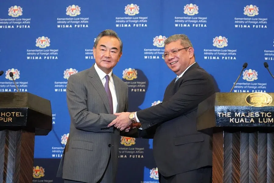 This handout photo taken and released on 12 July 2022 by Malaysia's Ministry of Foreign Affairs shows Malaysia's Foreign Minister Saifuddin Abdullah (right) and China's Foreign Minister Wang Yi shaking hands after a joint press conference at the Ministry of Foreign Affairs in Putrajaya. (Handout/Malaysia's Ministry of Foreign Affairs/AFP)