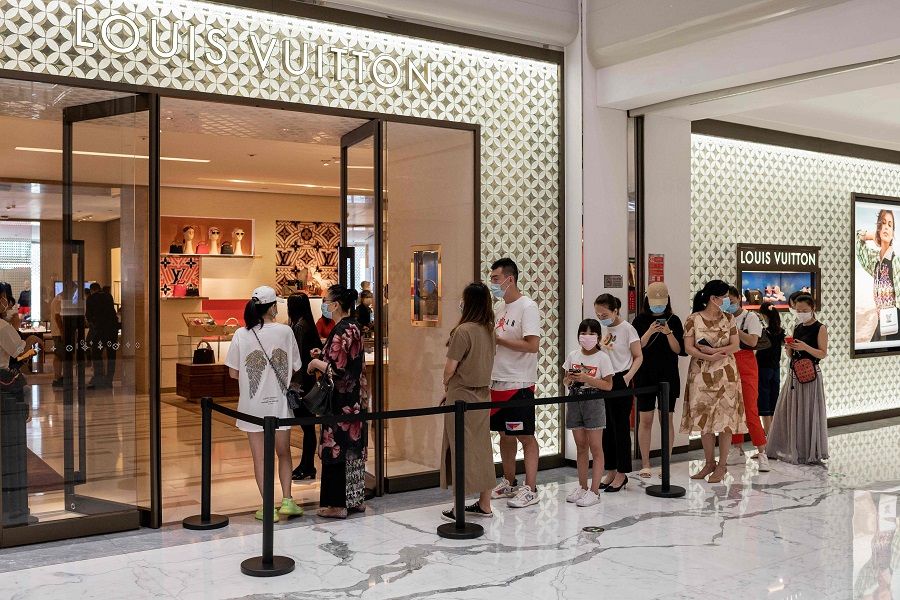 People queue to enter a Louis Vuitton shop at a mall in Beijing on 14 August 2020. (Nicolas Asfouri/AFP)