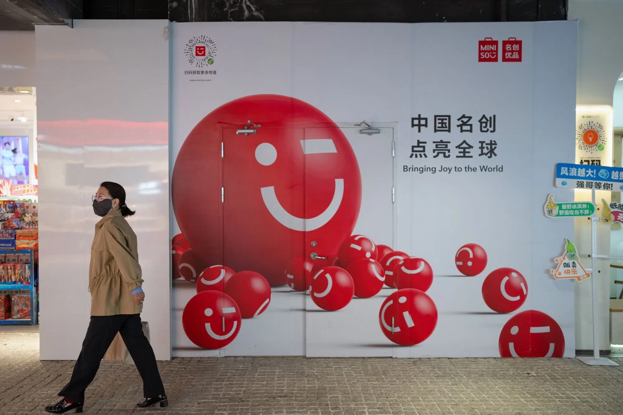 A woman walks past a Miniso store in Beijing, China on 25 September 2024.  (Na Bian/Bloomberg)