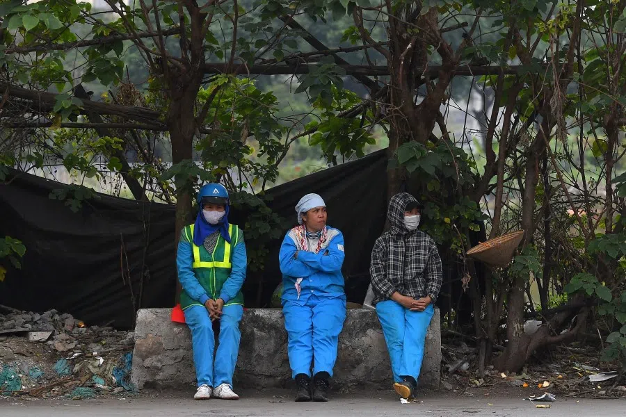 Workers rest on the side of a street in Hanoi on 5 January 2023. (Nhac Nguyen/AFP)