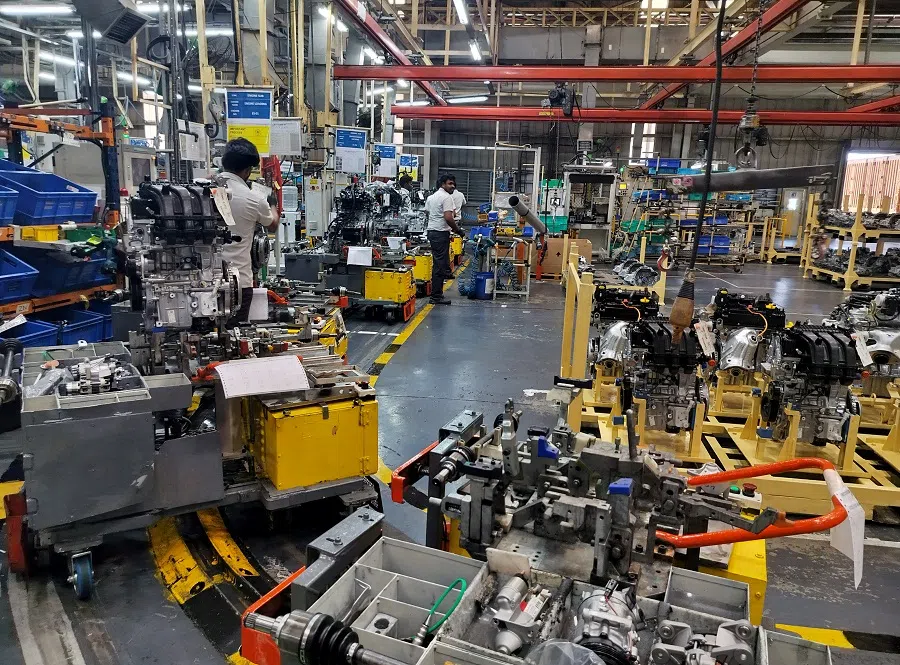 Employees work on a car wiring at an assembly line inside a manufacturing plant in Oragadam, Tamil Nadu, India, on 27 March 2024. (Praveen Paramasivam/Reuters)