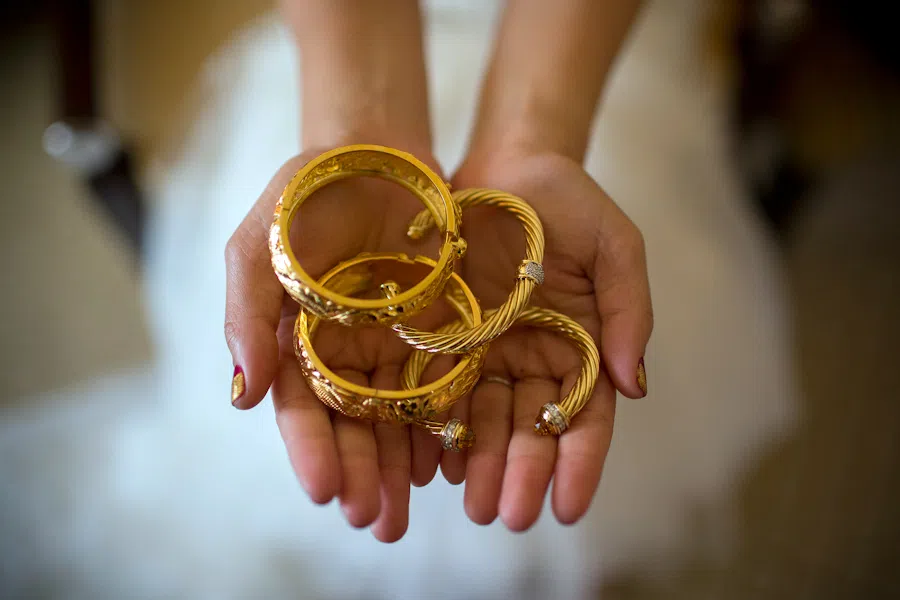 A bride holds gold bangles for a photograph during her wedding in Hong Kong.