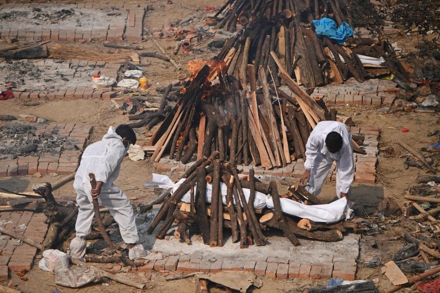 Relatives prepare the funeral pyre for their loved one, who died due to the Covid-19 coronavirus, before cremation at a cremation ground in New Delhi on 2 May 2021. (Tauseef Mustafa/AFP)