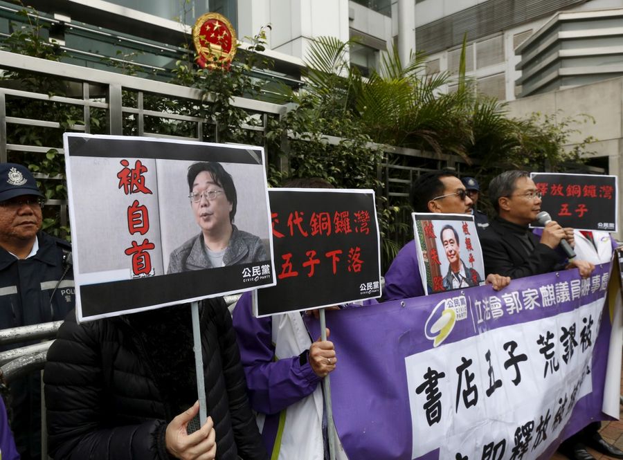 Pro-democracy activists carry a portrait of Gui Minhai (left) during a protest outside the Chinese Liaison Office in Hong Kong, on January 19, 2016. (REUTERS/Bobby Yip)