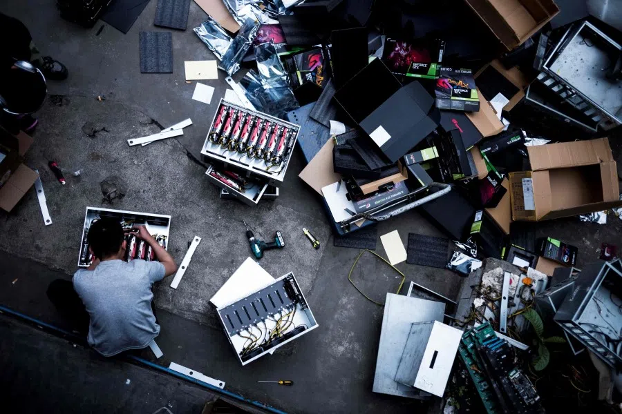 This photo taken on 3 April 2021 shows a worker installing new graphics cards at a cryptocurrency farm in Dujiangyan in China's southwestern Sichuan province. (STR/AFP)