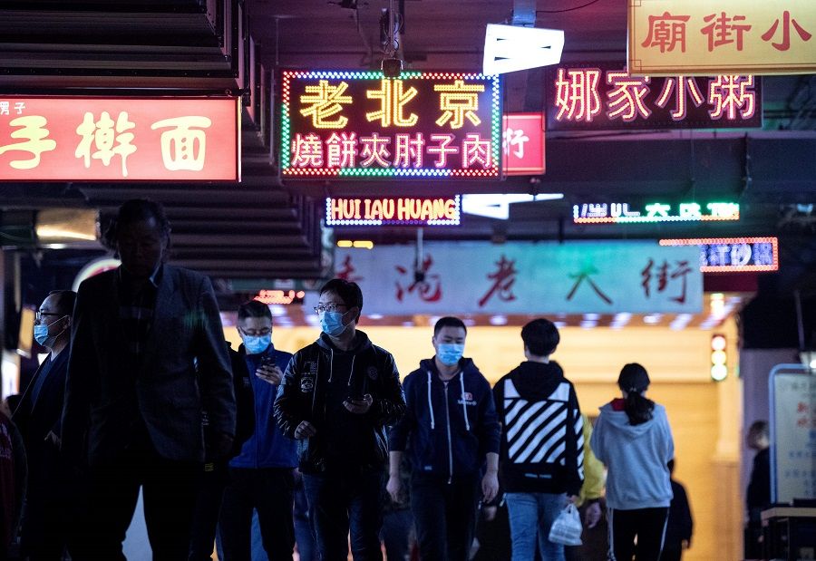 People wearing face masks arrive at a food court during lunch break in Beijing on 14 October 2020. (Noel Celis/AFP)